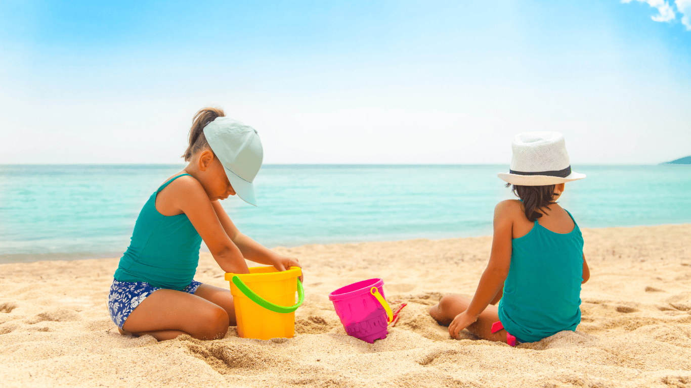 Niños jugando con palas y cubos en la playa